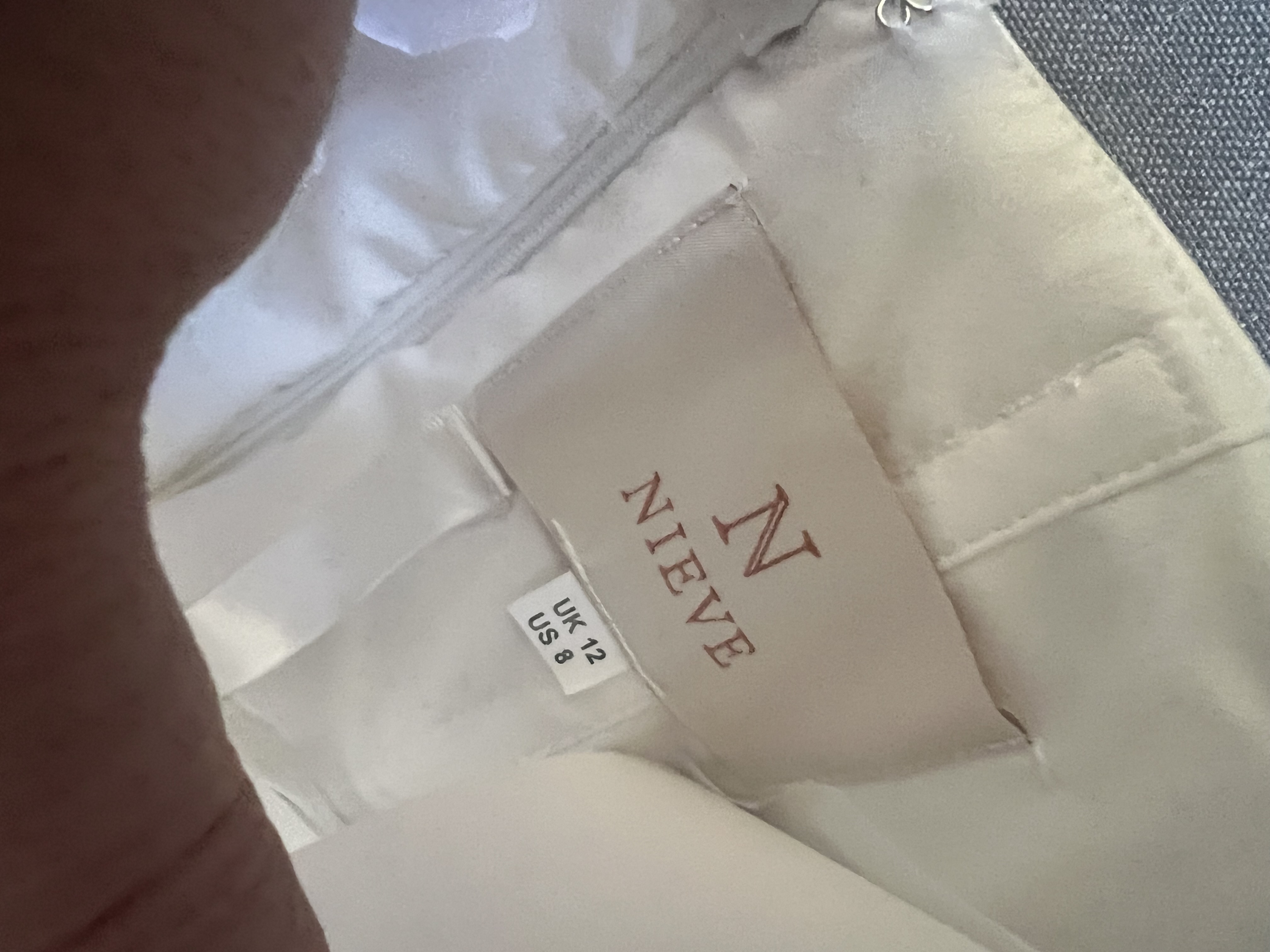 Close-up of the NIEVE designer label showing UK 12 and US 8