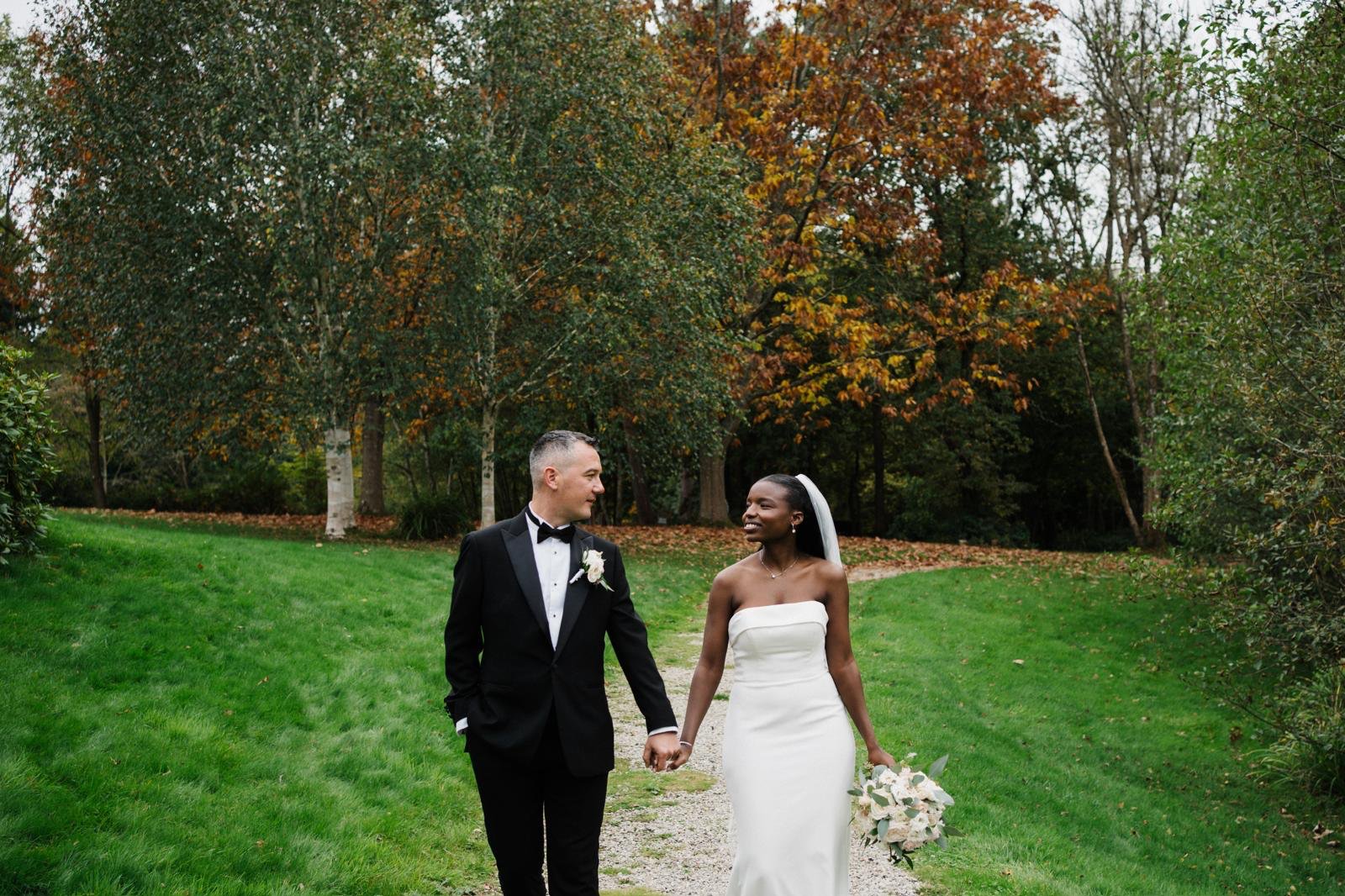 Sandra walking outdoors in the dress with autumn grounds behind her